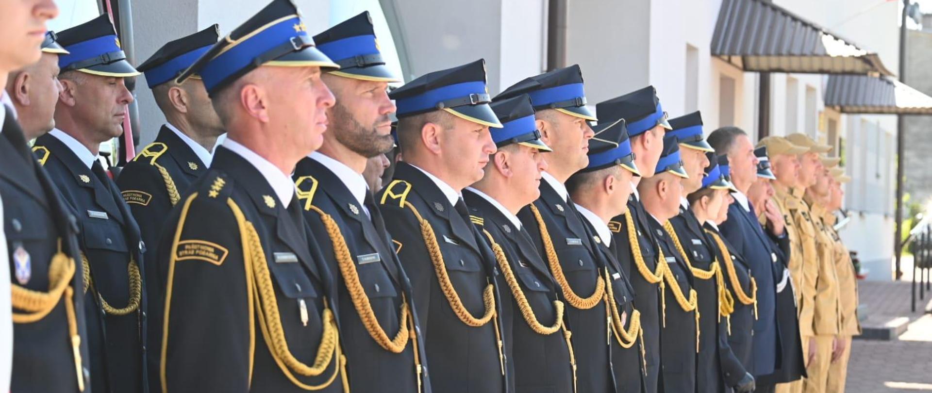 Zdjęcie przedstawia strażaków w umundurowaniu galowym podczas uroczystej zbiórki z okazji obchodów dnia strażaka w Lubaczowie