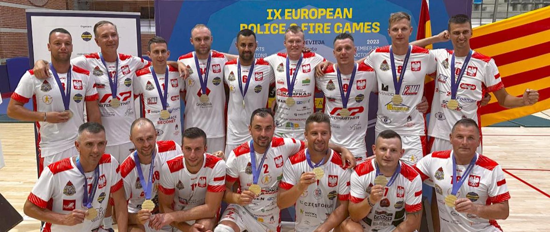 Zdjęcie grupowe Polskich reprezentantów ze złotymi medalami wewnątrz hali sportowej. 