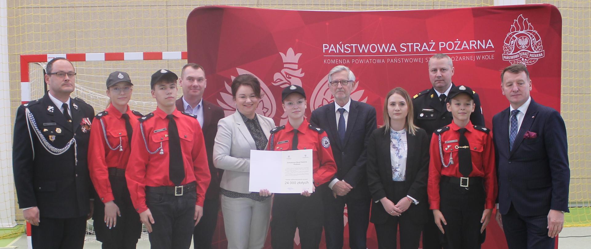 zdjecie grupowe strażaków, osób cywilnych oraz młodzieży w mundurach strażackich 