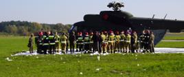 Zdjęcie przedstawia grupę strażaków i żołnierzy podczas szkolenia na temat ratownictwa technicznego w działaniach przy statkach powietrznych.