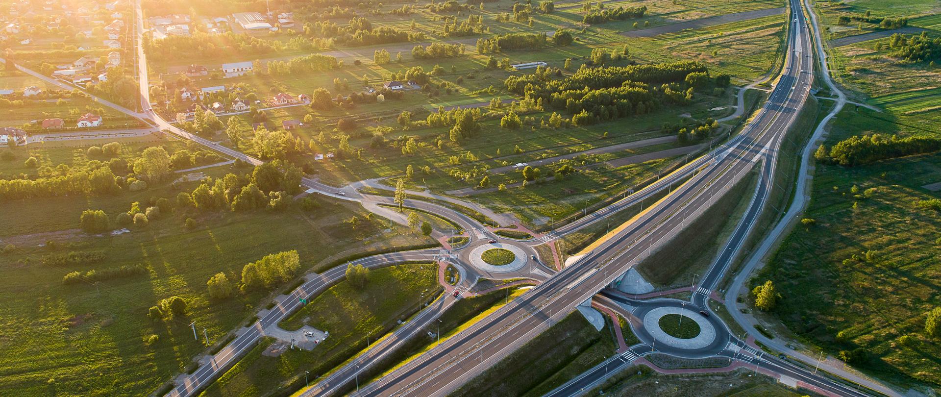 Widok z góry na węzeł na drodze ekspresowej S19. Zachód słońca z lewej strony.