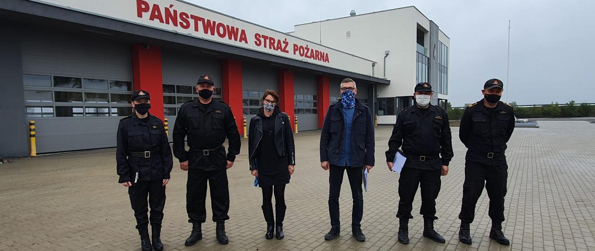 Sześć osób na tle nowego budynku Komendy
