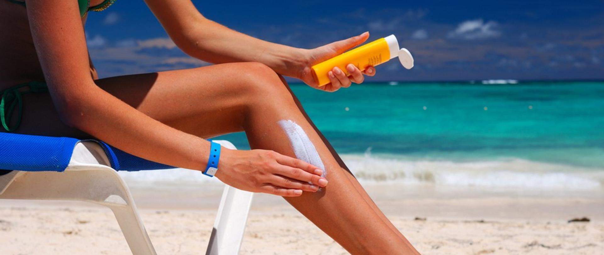 kobieta smaruje się kremem do opalania