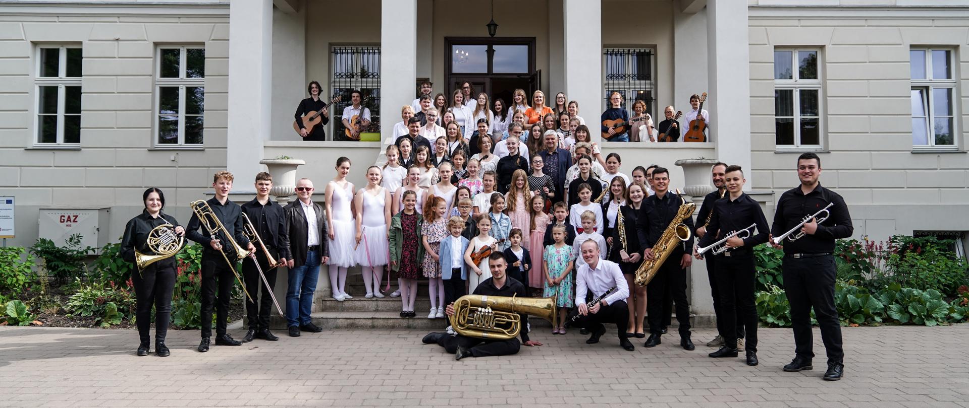 Uczestnicy festiwalu z instrumentami na schodach Pałacu Bonikowskich w Zychlinie