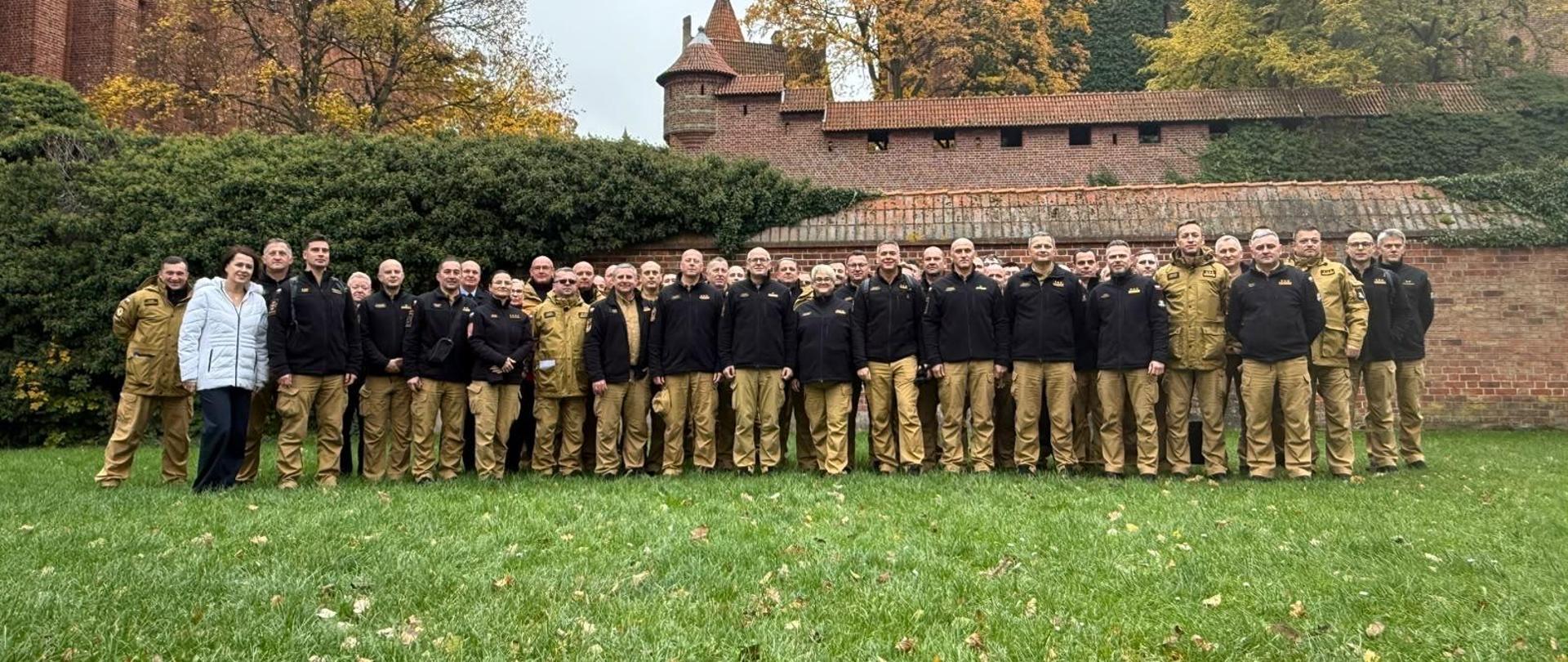 Zdjęcie grupowe na tle zamku w malborku
