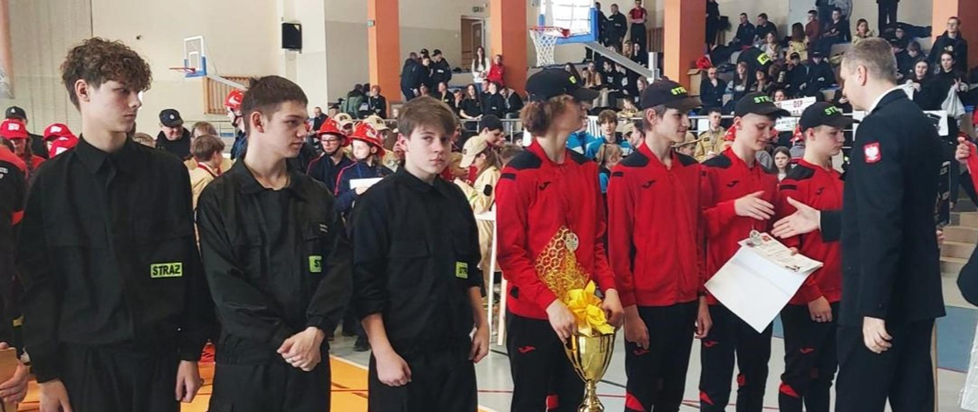 Zastępca komendanta głównego PSP wręcza medale dzieciom