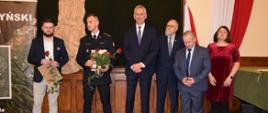 Zdjęcie przedstawia strażaka w mundurze wyjściowym w towarzystwie wręczających nagrodę w konkursie Krotoszyński Dąb 