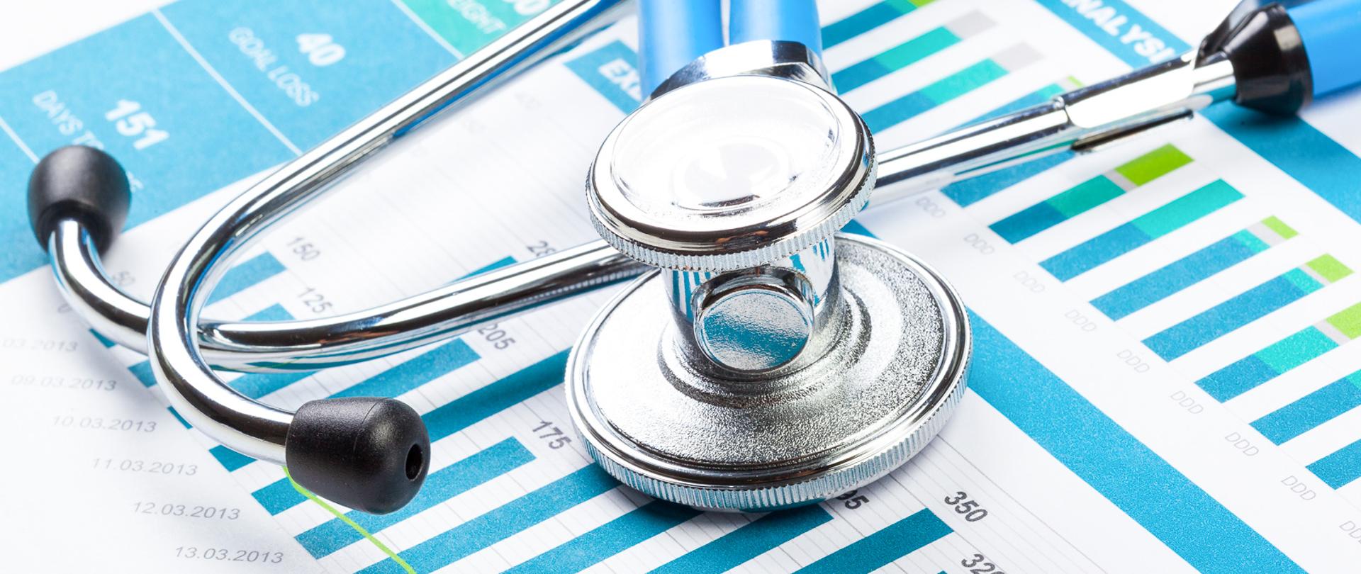 Stethoscope with financial on the desk.