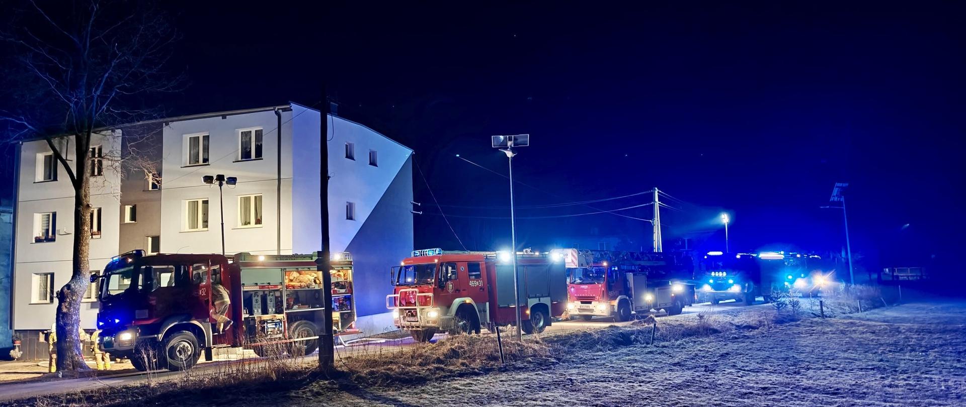 Samochody strażackie, budynek, pole.