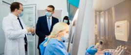 Premier rozmawia z lekarzem w laboratorium.