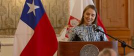 uroczystość z okazji 11 Listopada, przemowa Chargé d'affaires a.i. Mileny Łukasiewicz, w tle flagi polska i chilijska