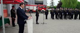 Zdjęcie przedstawia ministra, który przemawia podczas obchodów dnia strażaka
