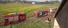 Samochody straży pożarnej stojące pod budynkiem, w którym wybuchł pożar