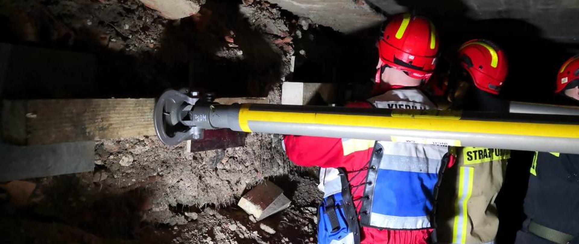 Strażacy montują podpory na niestabilnych ścianach. 