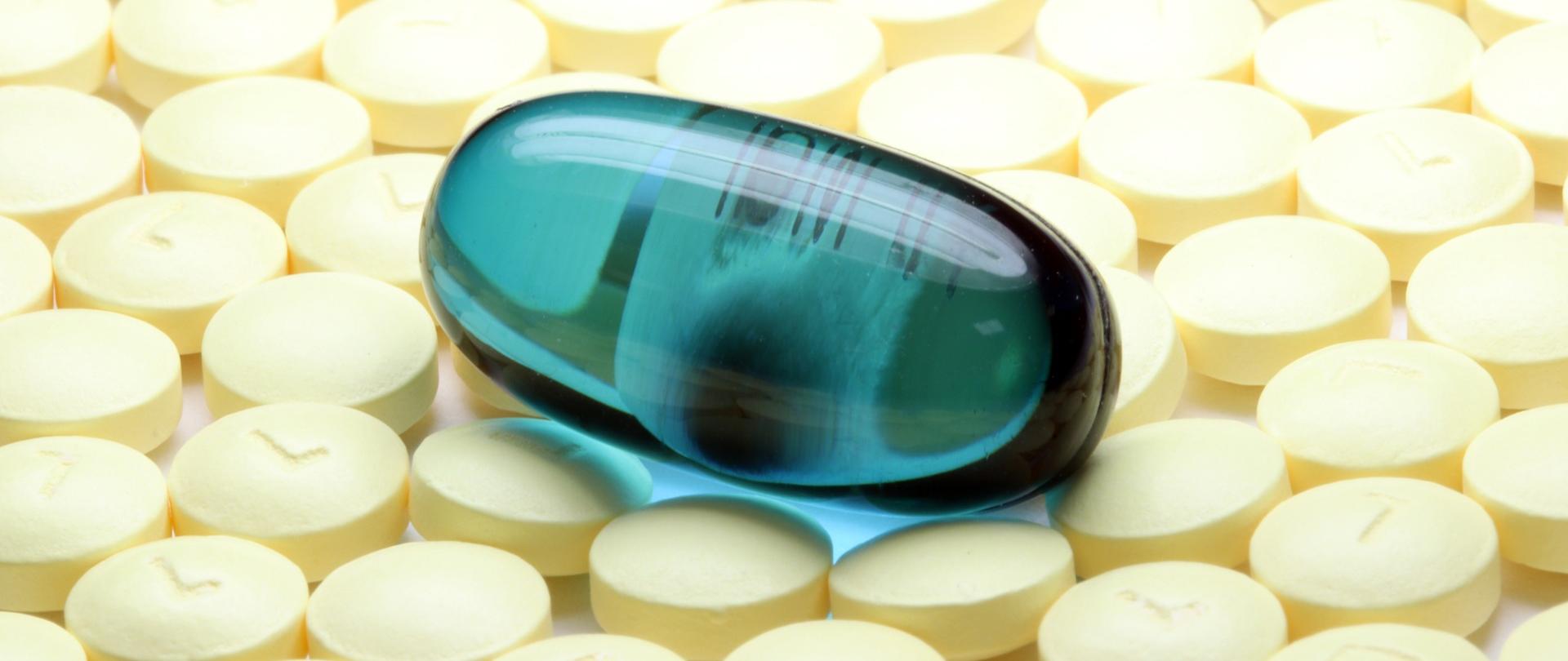 niebieska tabletka pośród żółtych.