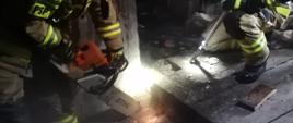 widoczni strażacy wycinający część stropu