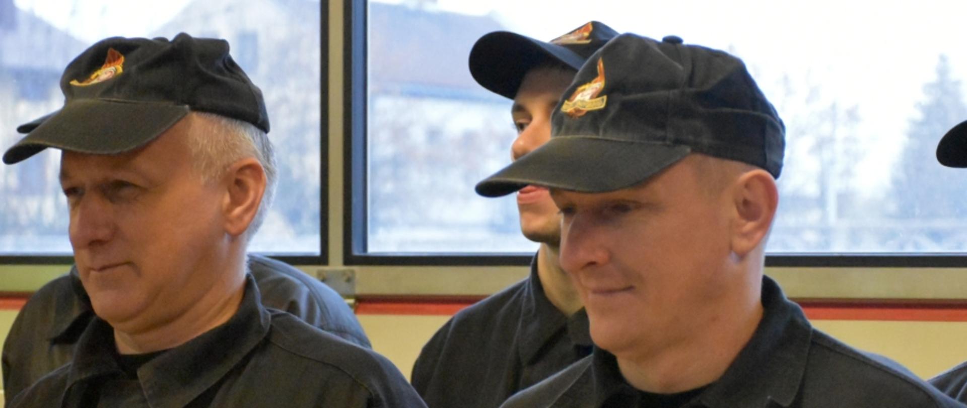 Zdjęcie przedstawia dwóch strażaków odchodzących na zaopatrzenie emerytalne. Stoją oni obok siebie w podczas uroczystej zmiany służby.