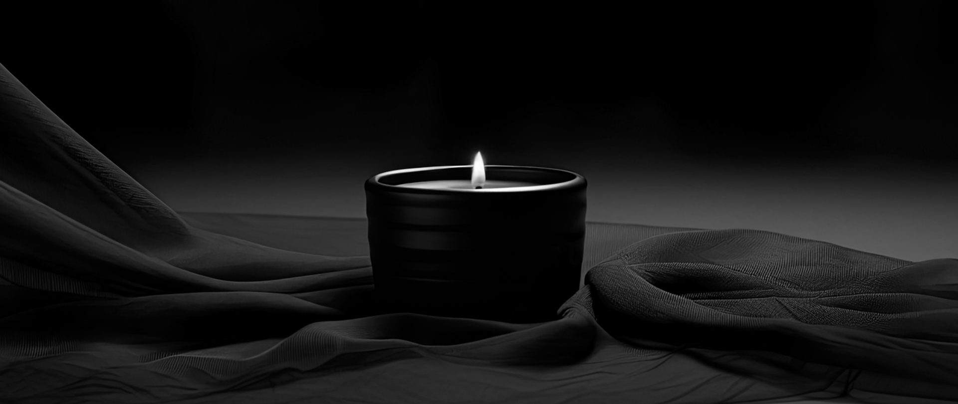 Nie żyje dr Roman Korban - zdjęcie zapalonej świecy położonej na pofałdowanej czarnej tkaninie