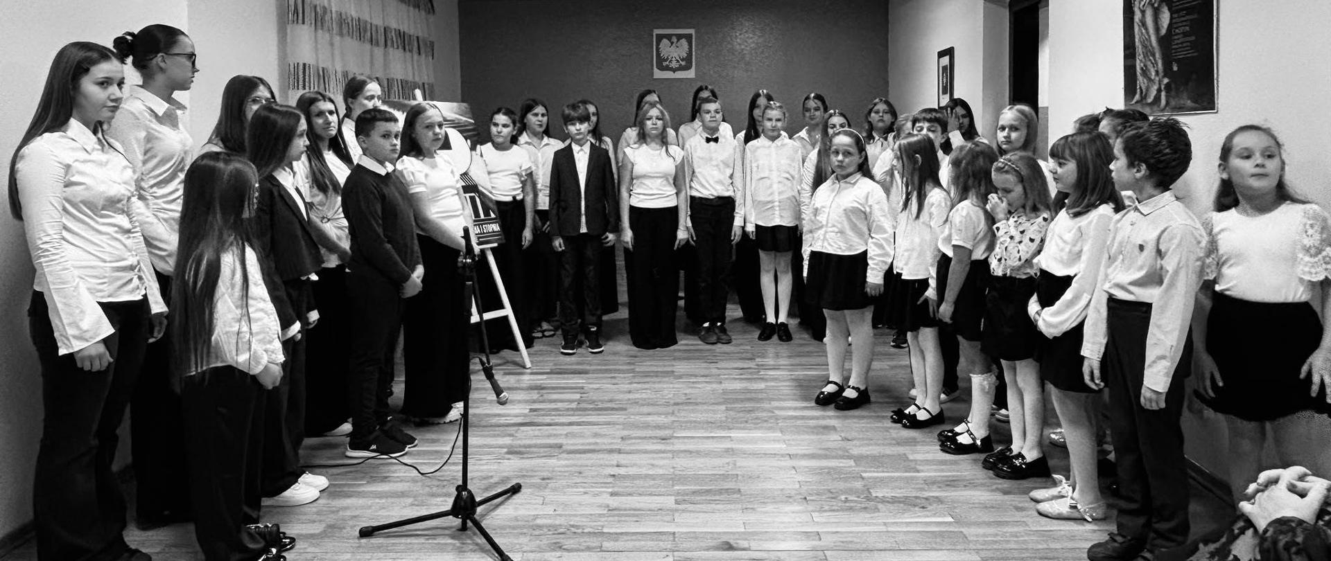 Uczniowie szkoły muzycznej stoją na sali koncertowej