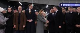 Na zdjęciu grupa osób w hali nowego dworca zachodniego, w śródku nich stoi minister Katarzyna Pełczyńska-Nałęcz