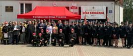 Zdjęcie przedstawia uczestników uroczystości na tle budynku remizy Ochotniczej Straży Pożarnej w Grabowie