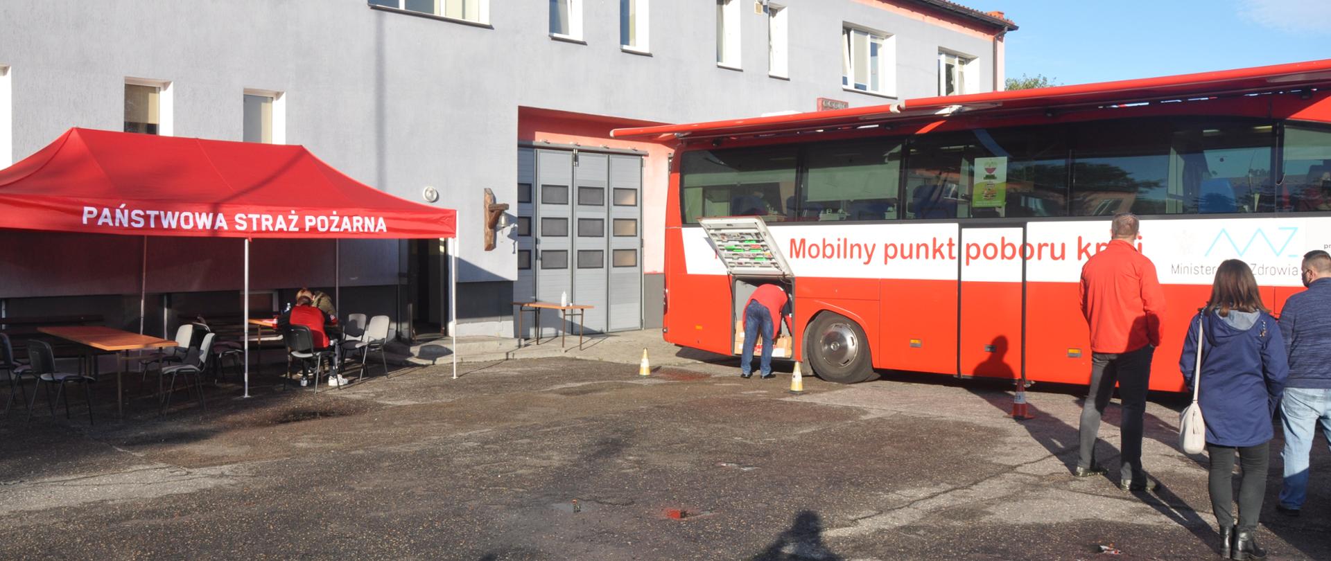 Na zdjęciu widoczny jest autobus oraz kolejka osób do oddania krwi