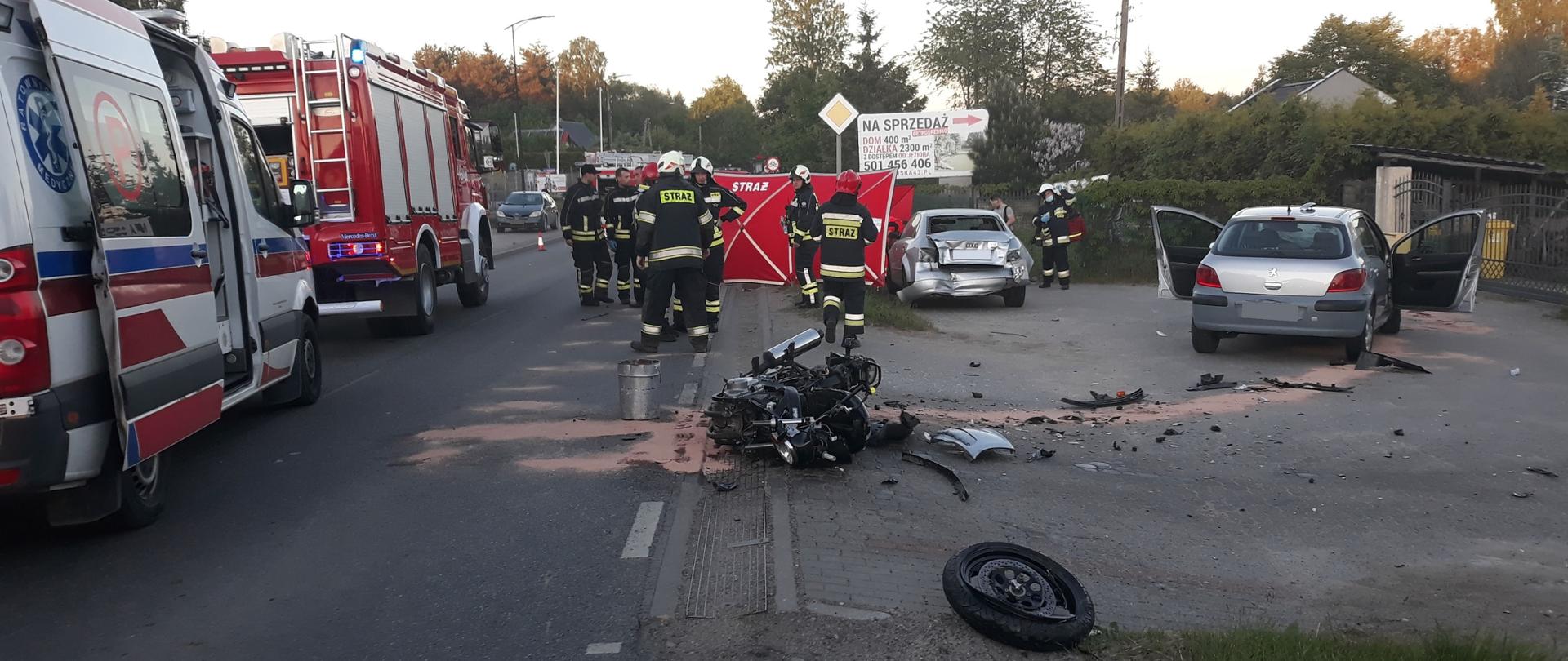 Teren działań. W tle uszkodzone pojazdy i samochody służb ratowniczych.