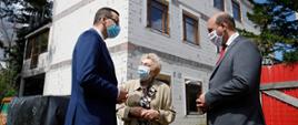 Premier Mateusz Morawiecki rozmawia ze starszą kobietą.