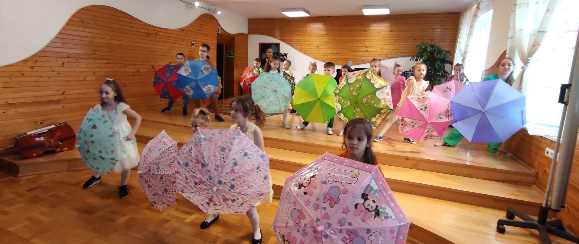 uczniowie tańczący z parasolkami