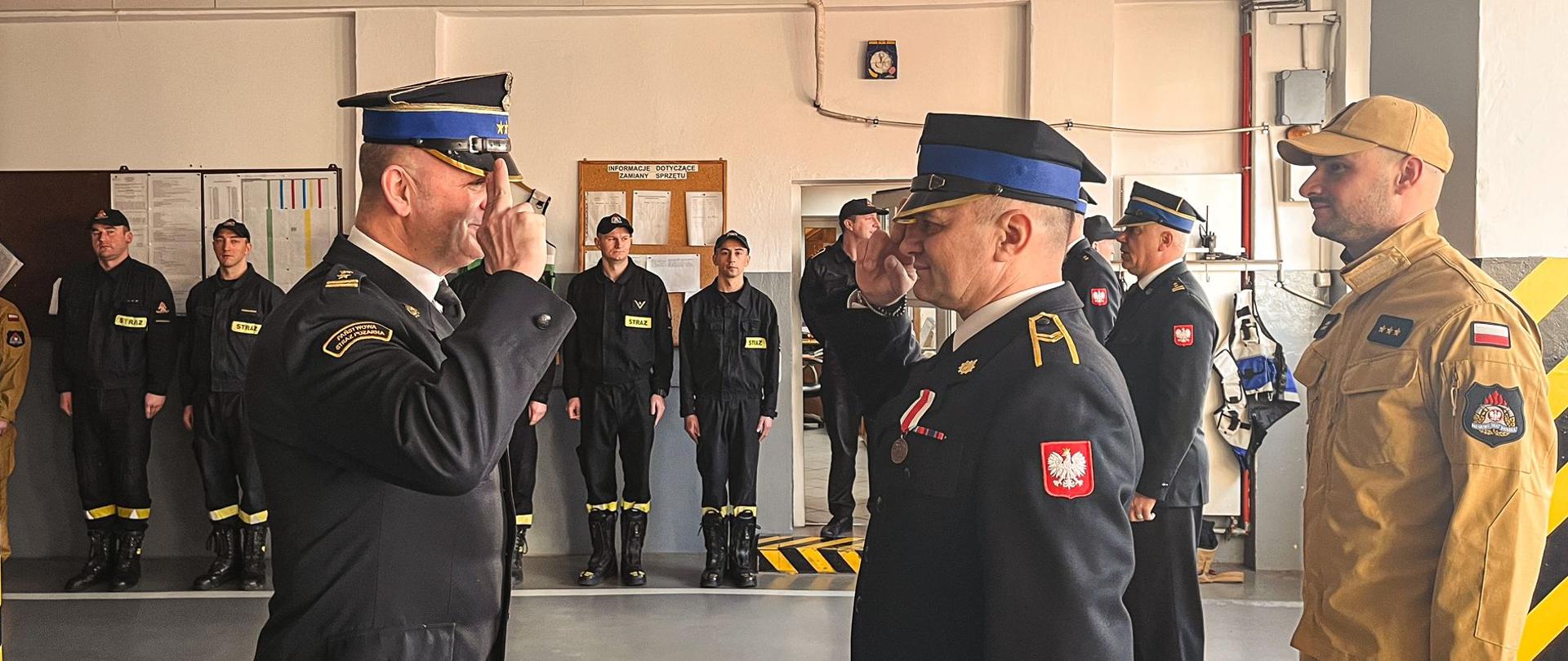 Komendant Powiatowy z Narcyzem Przybylskim w trakcie zdania obowiązków służbowych. Zdjęcie wykonane w garażu Jednostki Ratowniczo-Gaśniczej.