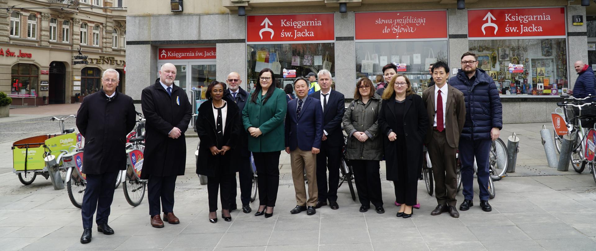Na zdjęciu przedstawiciele organizatorów Światowego Forum Miejskiego w Katowicach stojący na rynku w Katowicach pod zegarem odmierzającym czas do startu wydarzenia.