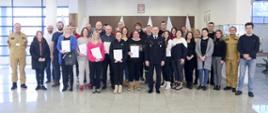 Grupowe zdjęcie uczestników szkolenia (26 osób) w towarzystwie Zastępcy Komendanta Centralnej Szkoły PSP, trzech oficerów CS PSP oraz kobiety
