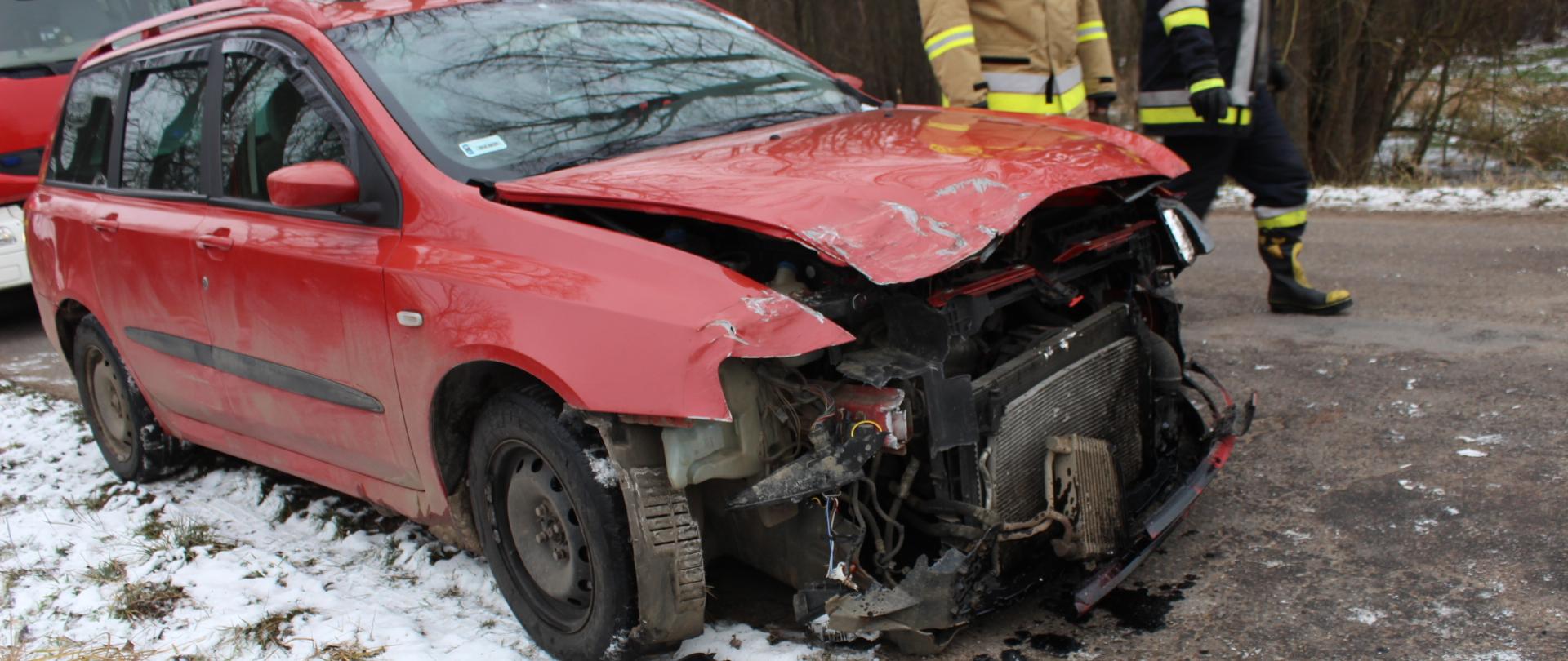 zdjęcie przedstawia rozbity przód samochodu osobowego koloru czerwonego