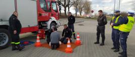 Na zdjęciu strażacy oraz policjanci uczą kierowcy udzielania pierwszej pomocy na fantomie szkoleniowym