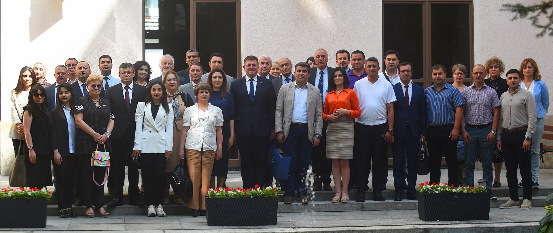 Zdjęcie zbiorowe, przed budynkiem stoi duża grupa ludzi.