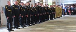 Dzień Strażaka w Komendzie Powiatowej PSP w Lubaniu
Pododdział strażaków stoi w dwuszeregu na zbiórce w garażu.