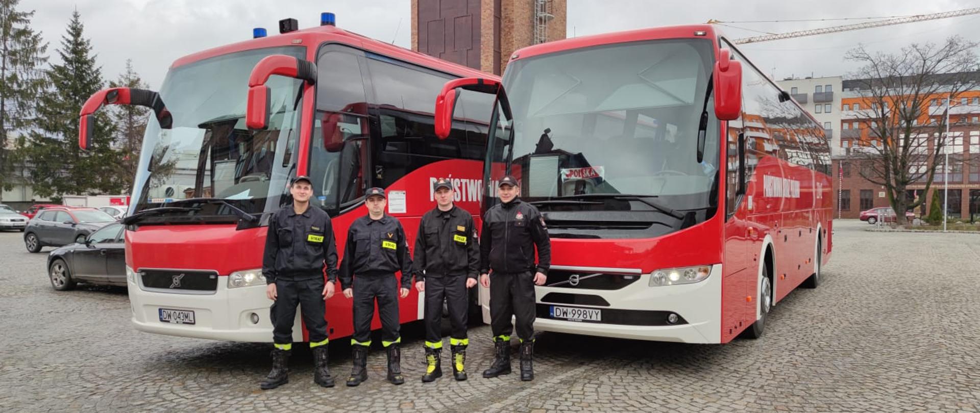 Strażacy na tle autobusów