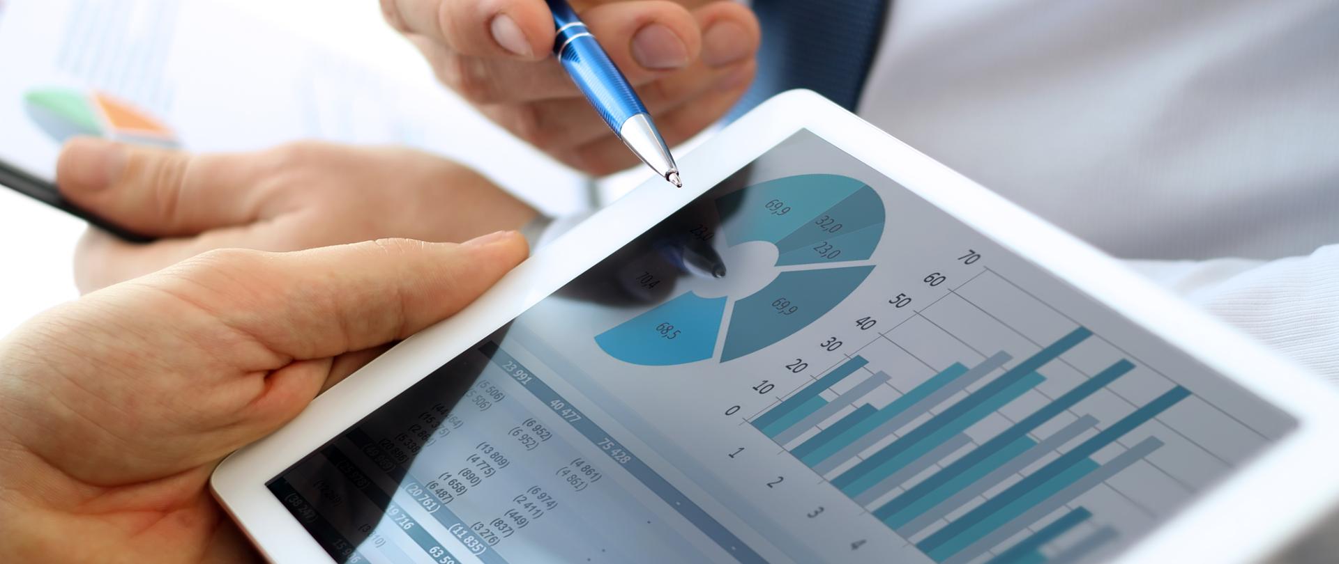 Business colleagues working and analyzing financial figures on a digital tablet