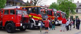 Widok z boku. Wystawa samochodów pożarniczych i mieszkańcy Andrychowa w trakcie oglądania sprzętu.