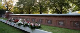 Wiązanki kwiatów leżą na grobach poległych obrońców Poczty Polskiej.