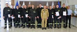 Grupowe zdjęcie uczestników szkolenia (16 osób) w towarzystwie Zastępcy Komendanta Centralnej Szkoły PSP oraz dwóch funkcjonariuszy Szkoły sprawującymi nadzór nad szkoleniem