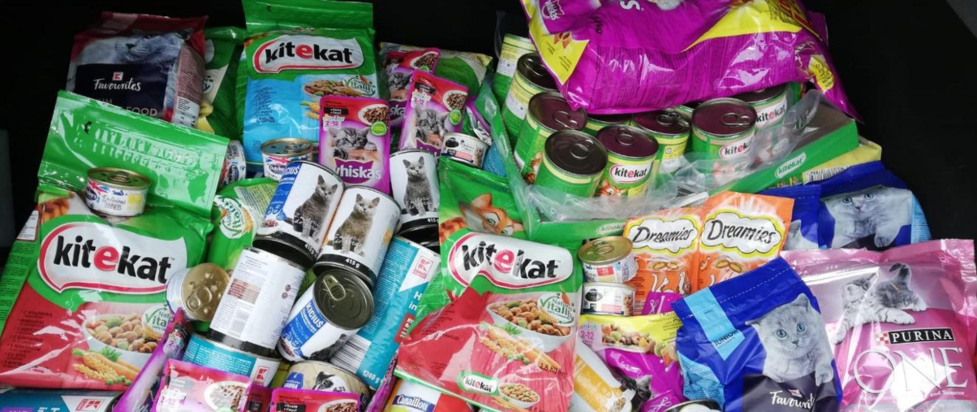 Fotografia przedstawia bagażnik samochodowy wypełniony zebraną podczas zbiórki karmą.