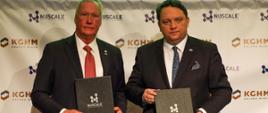 Prezes KGHM Polska Miedż Marcin Chludziński, obok niego po prawej stoi prezes i dyrektor generalny NuScale Power John Hopkin, obaj trzymają w dłoniach podpisaną umowę o współpracy między obiema firmami