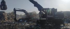 Pożar na składowisku odpadów. Plac składowy jednej z firm zajmującej się m.in. przetwarzaniem odpadów. Na placu pracują dwie koparki, które rozbierają wcześniej objętą pożarem hałdę.
