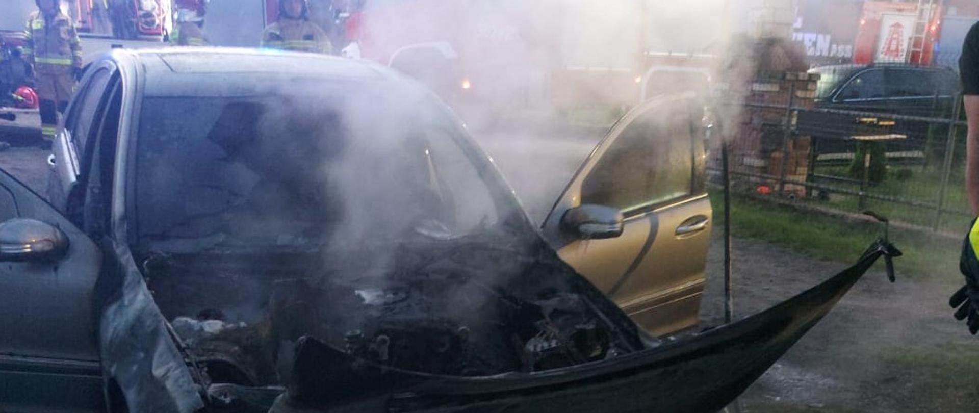 Zdjęcie przedstawia zniszczony przez pożar samochód osobowy. 