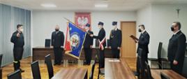 Zdjęcie przedstawia funkcjonariuszy Państwowej Straży Pożarnej podczas uroczystego ślubowania. Na zdjęciu widoczni funkcjonariusze w mundurach wyjściowych oraz sztandar Komendy Miejskiej w Częstochowie. 