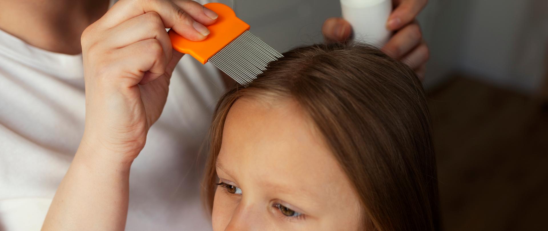 Zdjęcie przedstawia dziecko oraz matkę, która przy pomocy grzebienia wyczesuje wszy z włosów dziewczynki.
