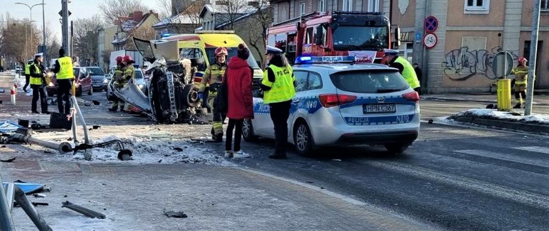 Zdjęcie przedstawia wypadek z udziałem auta osobowego. Na zdjęci służby biorące udział w zdarzeniu.