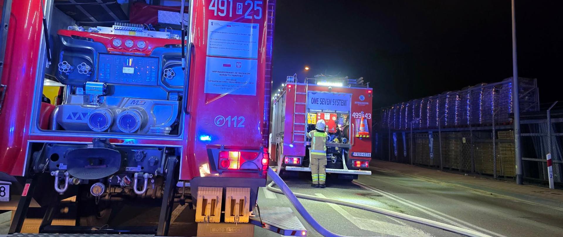 Zdjęcie przedstawia samochody straży pożarnej na ulicy podczas dzialań gaśniczych.