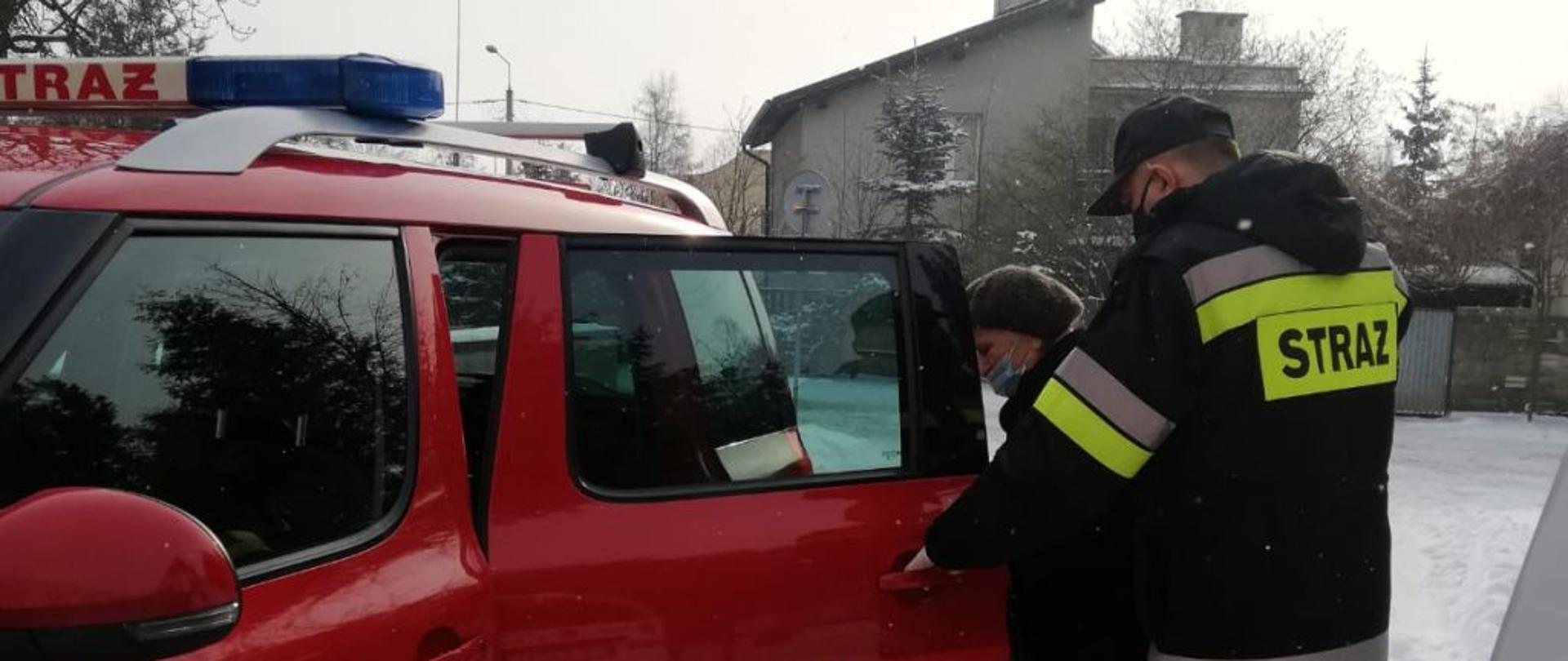 Na zdjęciu widnieją strażacy transportujący osoby starsze na szczepienie przeciwko COVID-19. 